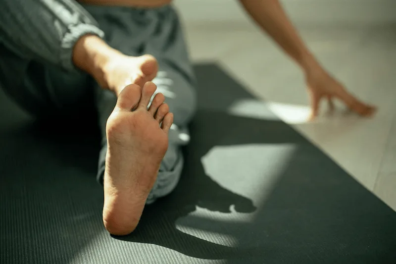 Patient performing a gentle foot stretch exercise as part of a neuropathy physical therapy routine.
