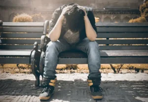 low section young man with pain sitting road
