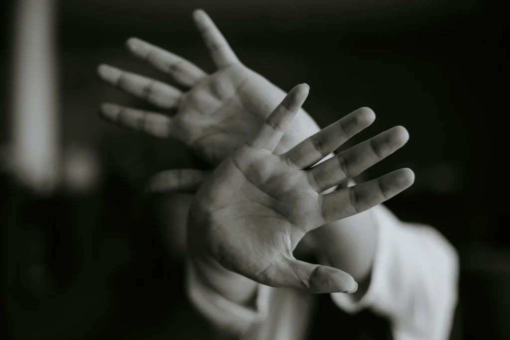 Black and white hands gently touching, symbolizing the contrast of pain and relief in neuropathy, used to represent healing, connection, and holistic home remedies.